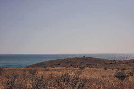 the sea blue skies the hills and carの写真素材