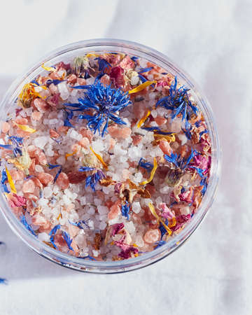 bath salt with flowers on a light background