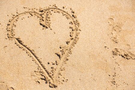 Heart love drawn on beach sand