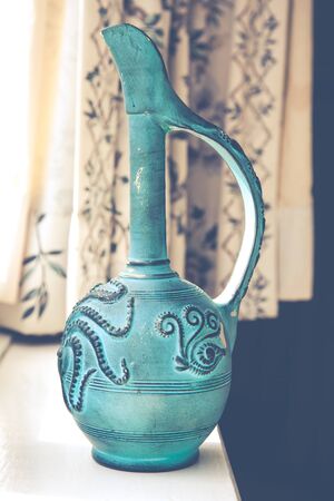 Old clay ceramic vase next to window still lifeの写真素材
