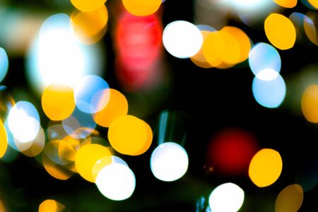 Vibrant coloured lights blinks defocused Christmes tree background