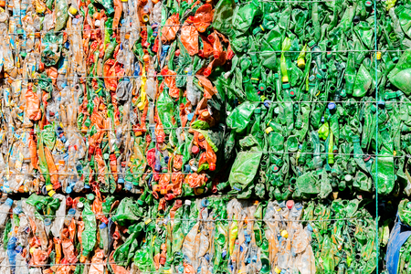 Old used plastic botteles collected for recycling. Tightened and stacked in big cubes