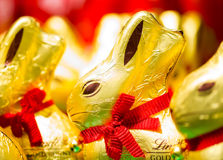 Easter bunny Lindt chocolate on shelves in supermarket for sale wrapped in golden foil. Lindt & Sprüngli  produces the highest quality premium chocolate in high ethical and sustainability standards. 13 March 2017.の写真素材