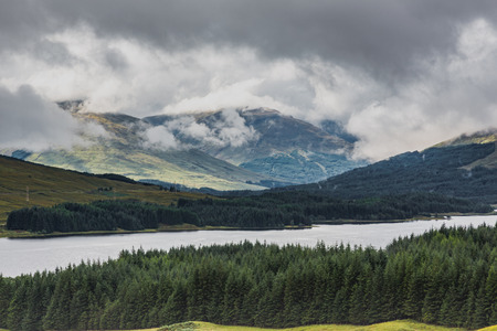 Dynamic and dramatic storm clouds over Scottish Highlands and lakes. Horizontal full frame landscape...