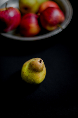 Red apples, green pears and yellow quinces on dark background. Juice autumn fruits still life photography. Close up shot with selective focus and shallow depth of field.の写真素材