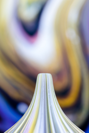 Handmade artistic craft glass ornaments in vibrant bright colours on abstract blurred backgroundの写真素材