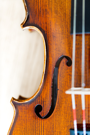 Focus on F hole in violin body belly. Top view, detaled macro with shalow depth of field on strings and bridgeの写真素材