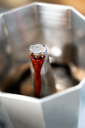 Strong fresh steaming coffe made in Italian style cafetiere. Cloce up, high angle view with selective focus on coffee. Full frame macro cropの写真素材