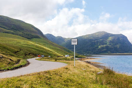 Slow-driving car on single wavy, serpentine road in NC500, Scotlandの写真素材