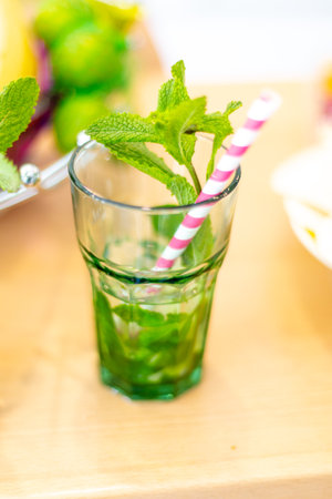 Glass of cold water and fresh mint with stripped strokes standing on table. Close up shot from topの写真素材