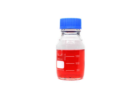A glass chemistry bottle with red liquid or solvent used for measurements on white background. A science lab equipment for lab testing and experiment.の写真素材