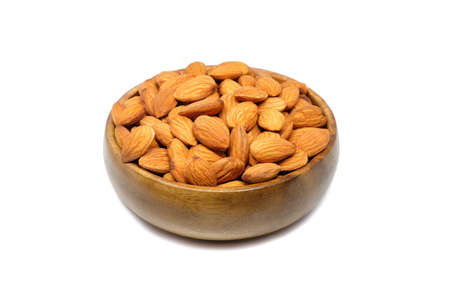 Roasted almonds in wood bowl on white background.の写真素材