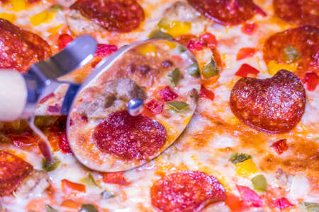 Close up view of a delicious pizza being cut into slicesの写真素材