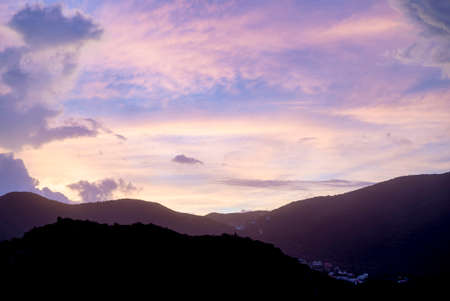 Sun setting during blue hour over hills and mountainsの写真素材
