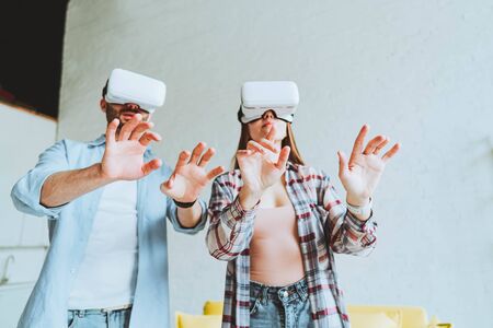 Young happy couple having fun with VR goggles headset glasses.
