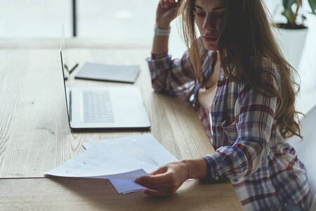 Frustrated upset brunette female freelancer has just got unpleasant bad news e-mail letter to her laptop and now she is thinking over it. Empty space conceptの写真素材
