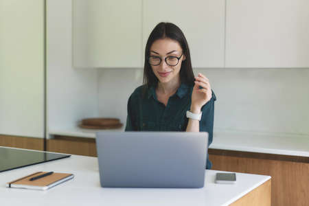 Front view of business woman working from home with laptop, smartphone and notebookの写真素材