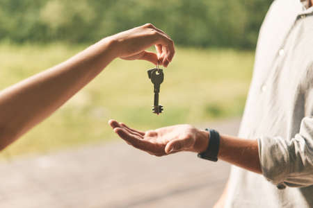 Close up of female real estate agent giving keys to manの写真素材