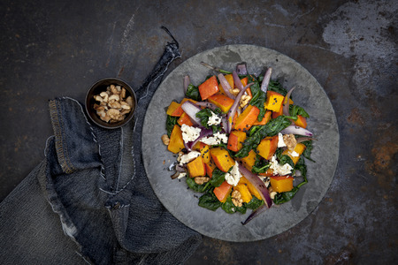 Pumpkin with baby spinach and sheepÃ ¢ â,¬ ~ s milk cheese on black backgroundの写真素材