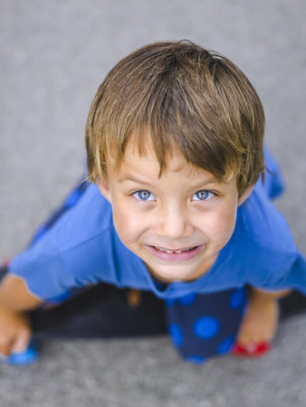 Blond boy playing on a children's playground and has funの写真素材
