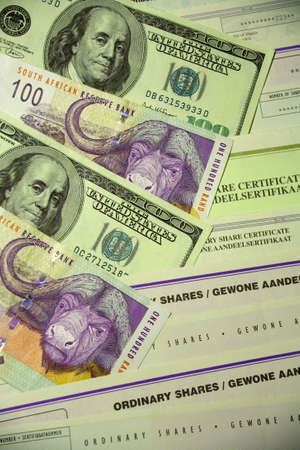 100 Dollar bills 100 Rand banknotes and various South African share certificates.の写真素材