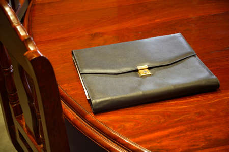 Close up of a meeting room with a wooden table, chair and desk pad.の写真素材