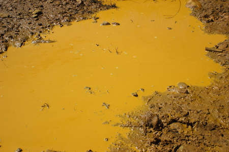 Still water forming an orange mud bath.の写真素材