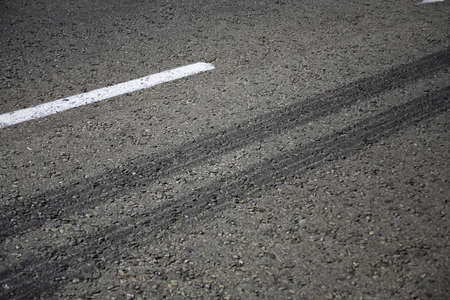 Close up view of rubber tyre tracks on a tar road from vehicles braking harshlyの写真素材