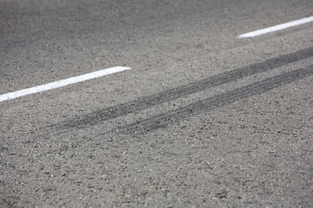 Close up view of rubber tyre tracks on a tar road from vehicles braking harshlyの写真素材