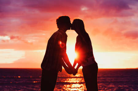 Silhouette of Young Romantic Couple at Sunsetの写真素材