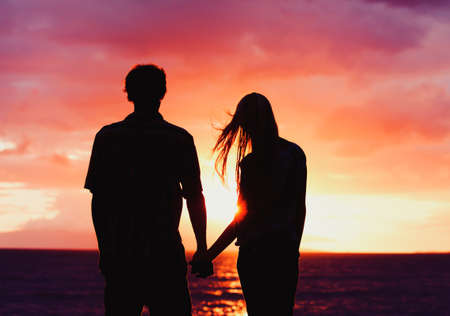 Silhouette of Young Romantic Couple at Sunsetの写真素材