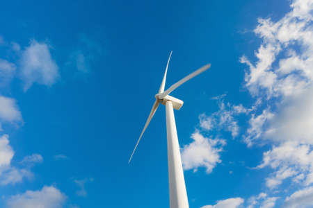 White Wind Turbine Generating Electricity on Blue Sky