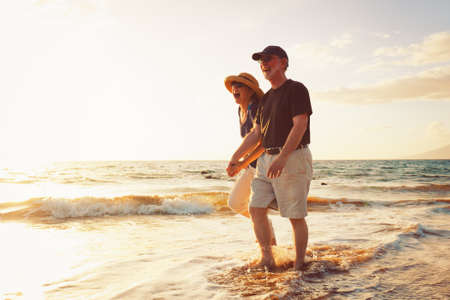 Senior Couple Enjoying Sunset at the Beachの写真素材