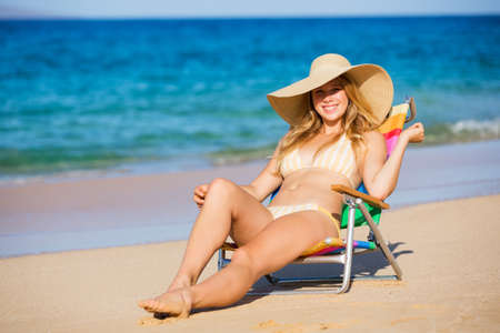 Young beautiful woman on the beach relaxing in the sunの写真素材