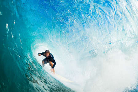 Surfer on Blue Ocean Wave in the Tube Getting Barreled Surfer on Blue Ocean Wave in the Tube Getting Barreled