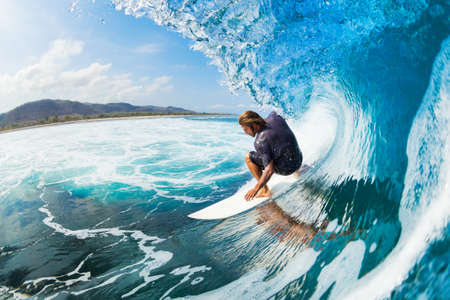 Surfer on Blue Ocean Wave in the Tube Getting Barreled Surfer on Blue Ocean Wave in the Tube Getting Barreled