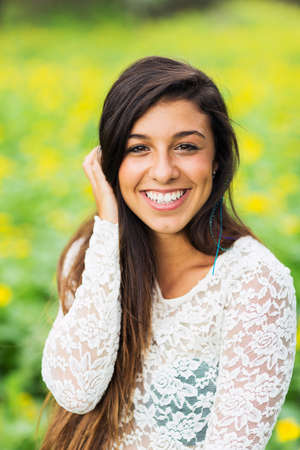 Outdoor portrait of a beautiful young brunette woman smiling happyの写真素材