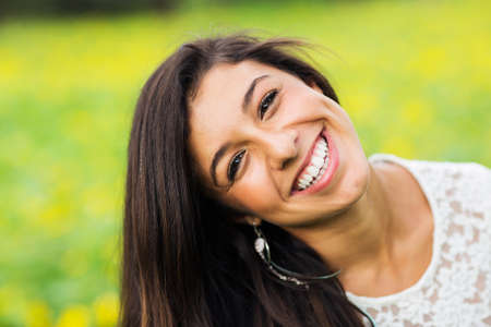 Outdoor portrait of a beautiful young brunette woman smiling happyの写真素材