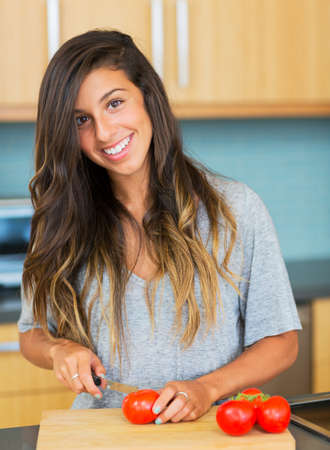 Young Woman Cooking Healthy Food at Home, Perparing Vegetables for Salad. Lifestyle Conceptの写真素材