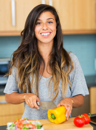 Young Woman Cooking Healthy Food at Home, Perparing Vegetables for Salad. Lifestyle Conceptの写真素材