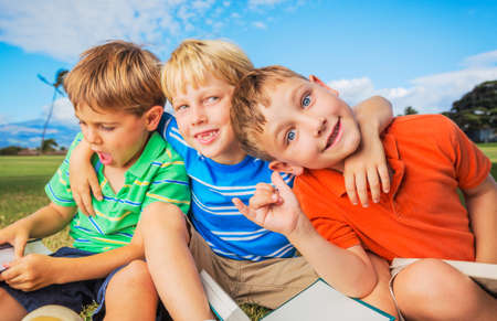 Group of Happy Kids Reading Books Outside, Friendship and Learning Concept