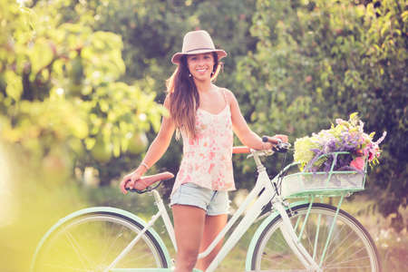 Beautiful young woman on bike in parkの写真素材
