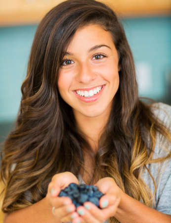 Beautiful Woman Holding a handfull of fresh blueberriesの写真素材