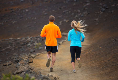Fitness sport couple jogging outside, training together outdoors. Running on amazing nature trailの写真素材