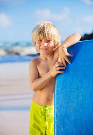 Happy Young boy having fun at the beach on vacation, with boogie boardの写真素材