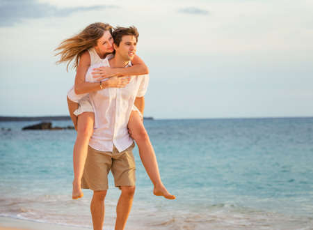 Romantic happy couple on the beach at sunset, man and woman in loveの写真素材