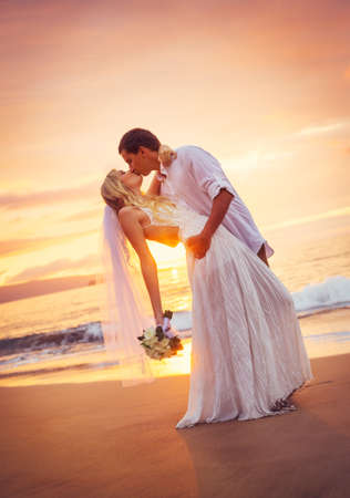 Bride and Groom, Kissing at Sunset on a Beautiful Tropical Beach, Romantic Married Coupleの写真素材