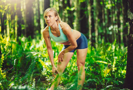 Athletic Woman Stretching Before going for Run in the Forestの写真素材