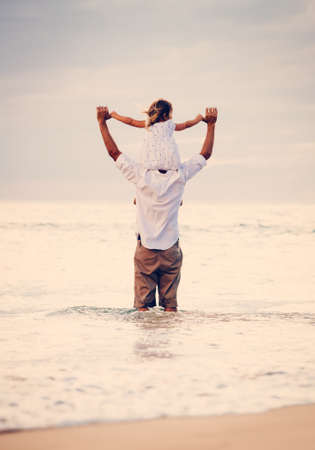 Father and Daughter Playing Together at the Beach at Sunset. Happy Fun Smiling Lifestyleの写真素材
