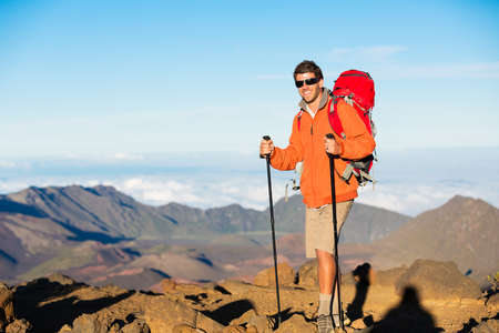 Hiker with backpack standing on mountain top enjoying the viewの写真素材